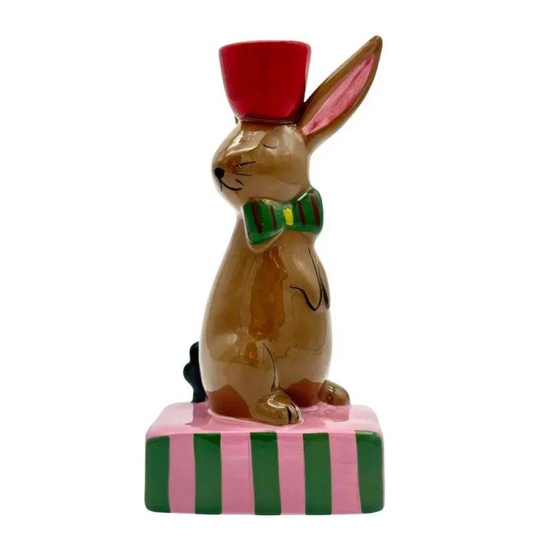 Kerzenständer, braunes Kaninchen mit Schleife und kleinem Podest in Konstrast farben rosa, grün und rot, rote Kerzentülle für Stabkerzen auf dem Kopf des Kaninchens, aufrecht sitzendender Hase