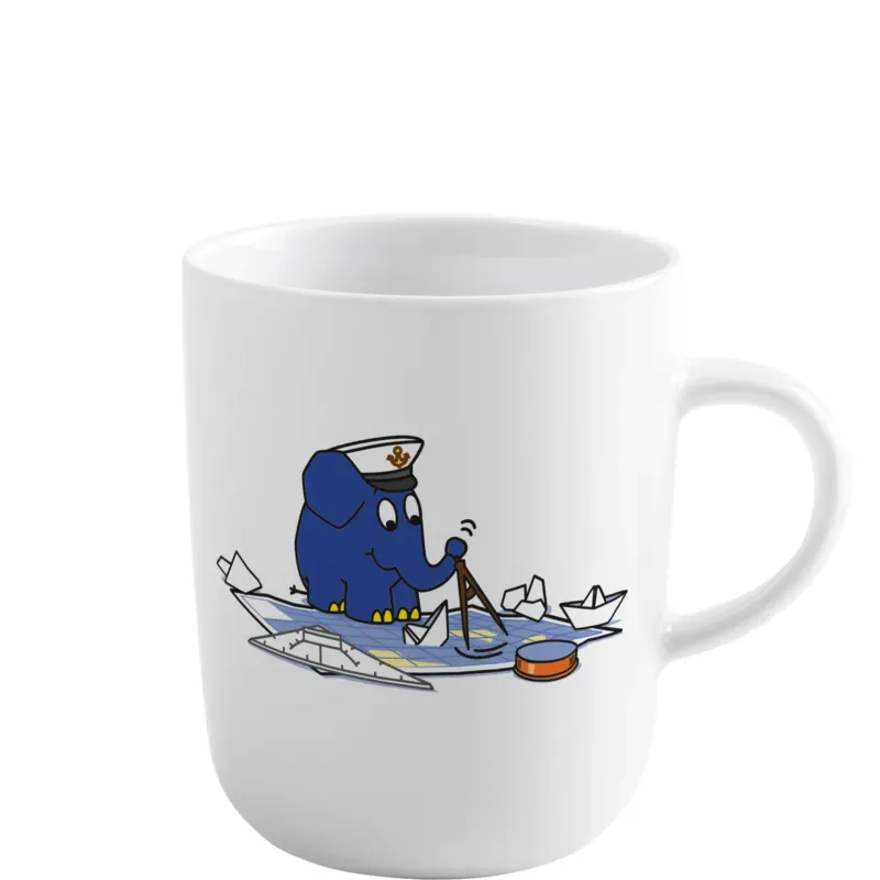Weiße Tasse mit einem blauen Elefanten im Matrosenanzug, der mit einem Kompass auf einem Papierboot sitzt. Um ihn herum treiben weitere Papierboote im Wasser. Die Tasse ist schlicht gestaltet und hat einen runden Henkel.