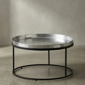 Freigestellter runder Couchtisch mit silberner Aluminiumplatte und schwarzem Metallrahmen frontal vor weißem Hintergrund._#sku_BARWL6.692#