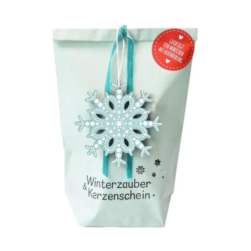 Hellblaue Wundertüte mit einer an der Tüte angehangenen blauen Schneeflocke und der schwarze Text daruner "Winterzauber und Kerzenschein"