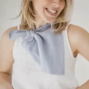 Close-up detail of light blue linen neckerchief showing pre-stitched loop and triangle drape